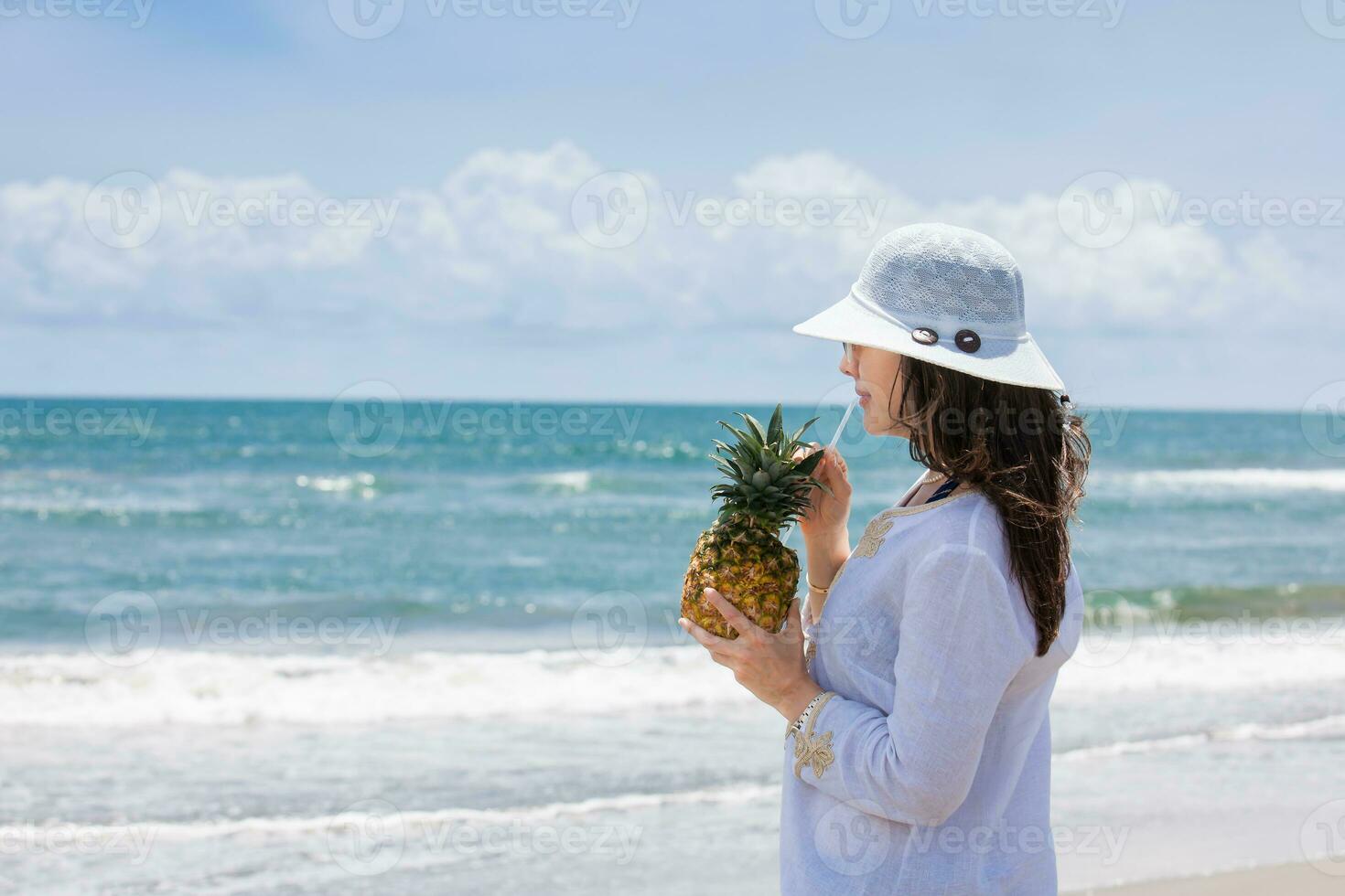 Woman having a tropical drink at a paradisiac tropical beach in a beautiful sunny day photo