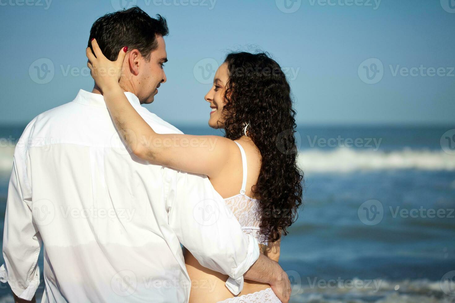 Couple at the beach waiting for their baby - 28 weeks photo