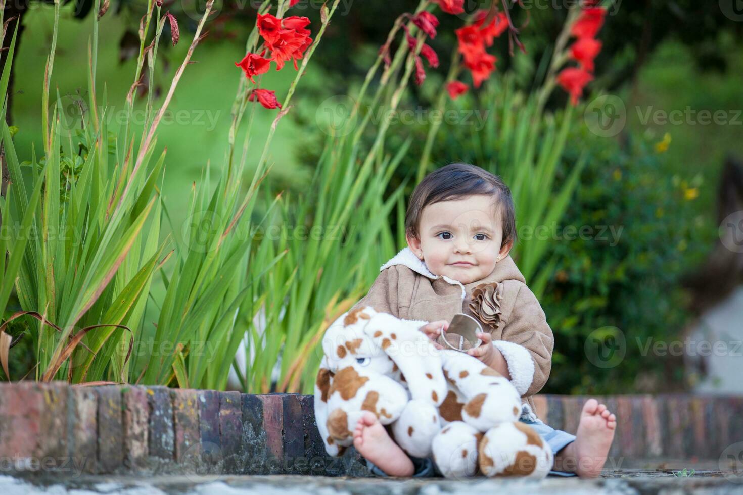 Sweet one year old baby girl playing outdoors. photo