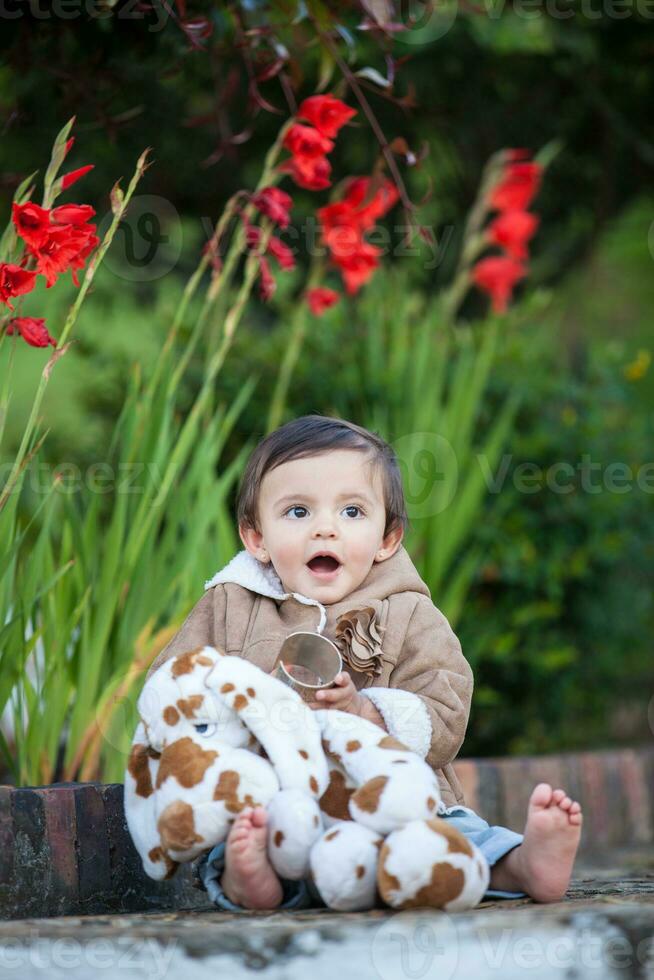 Sweet one year old baby girl playing outdoors. photo