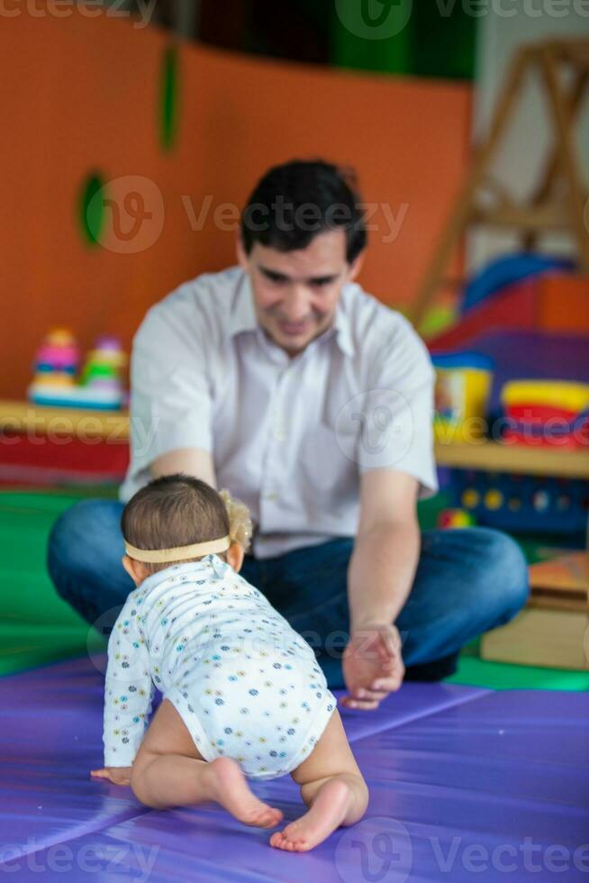 Portrait of a beautiful nine months baby playing with her dad. Crawling baby photo