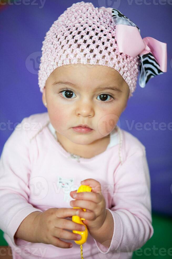 Portrait of a beautiful nine months baby playing on a colorful background. Learning concept photo