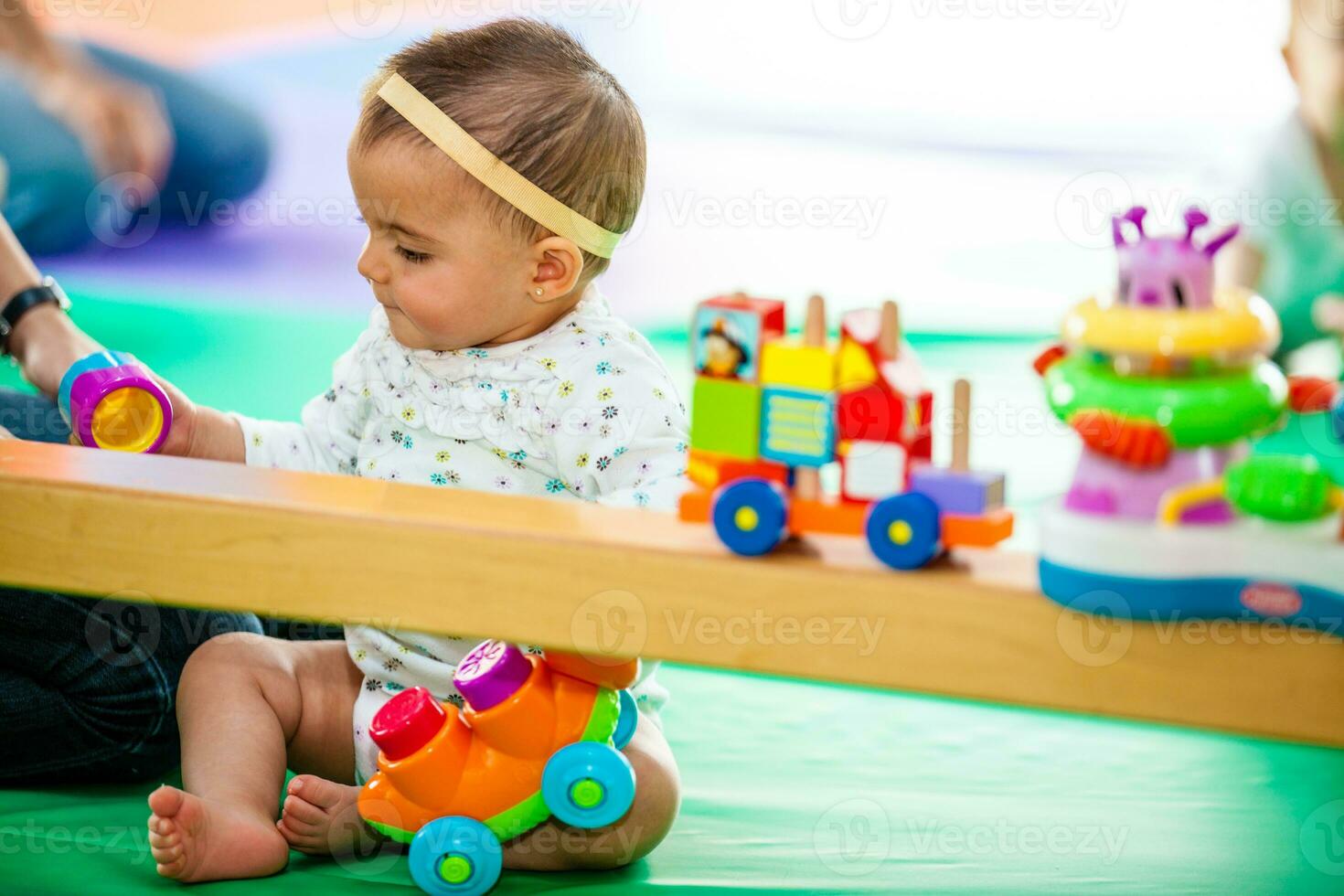 Portrait of a beautiful nine months baby playing on a colorful background. Learning concept photo