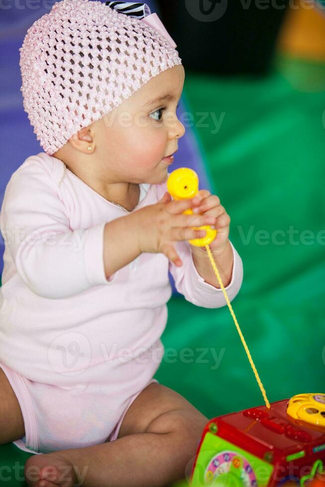 Portrait of a beautiful nine months baby playing on a colorful background. Learning concept photo