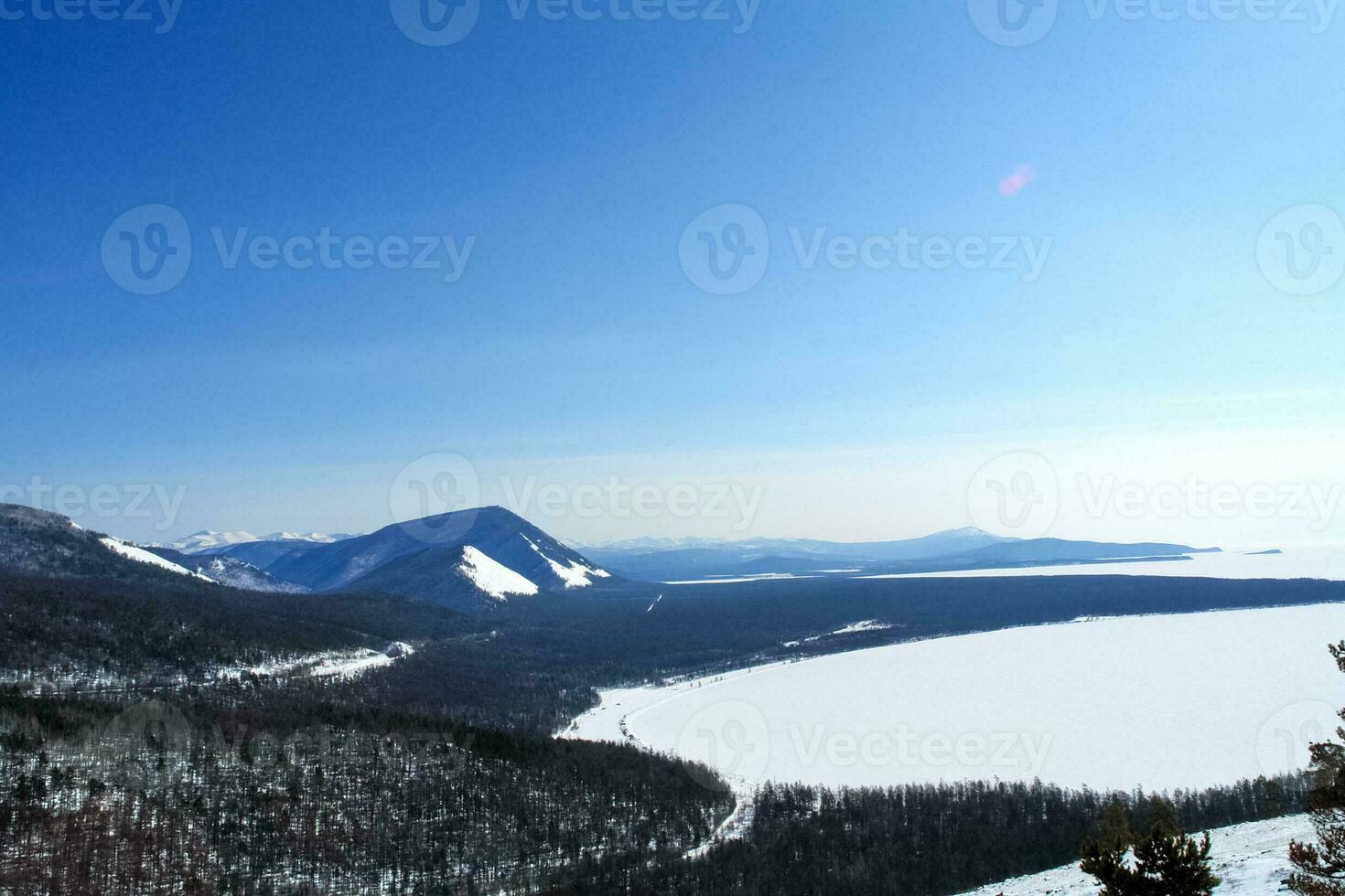 Baikal mountains in winter in snow. Forest in snow covered mount photo