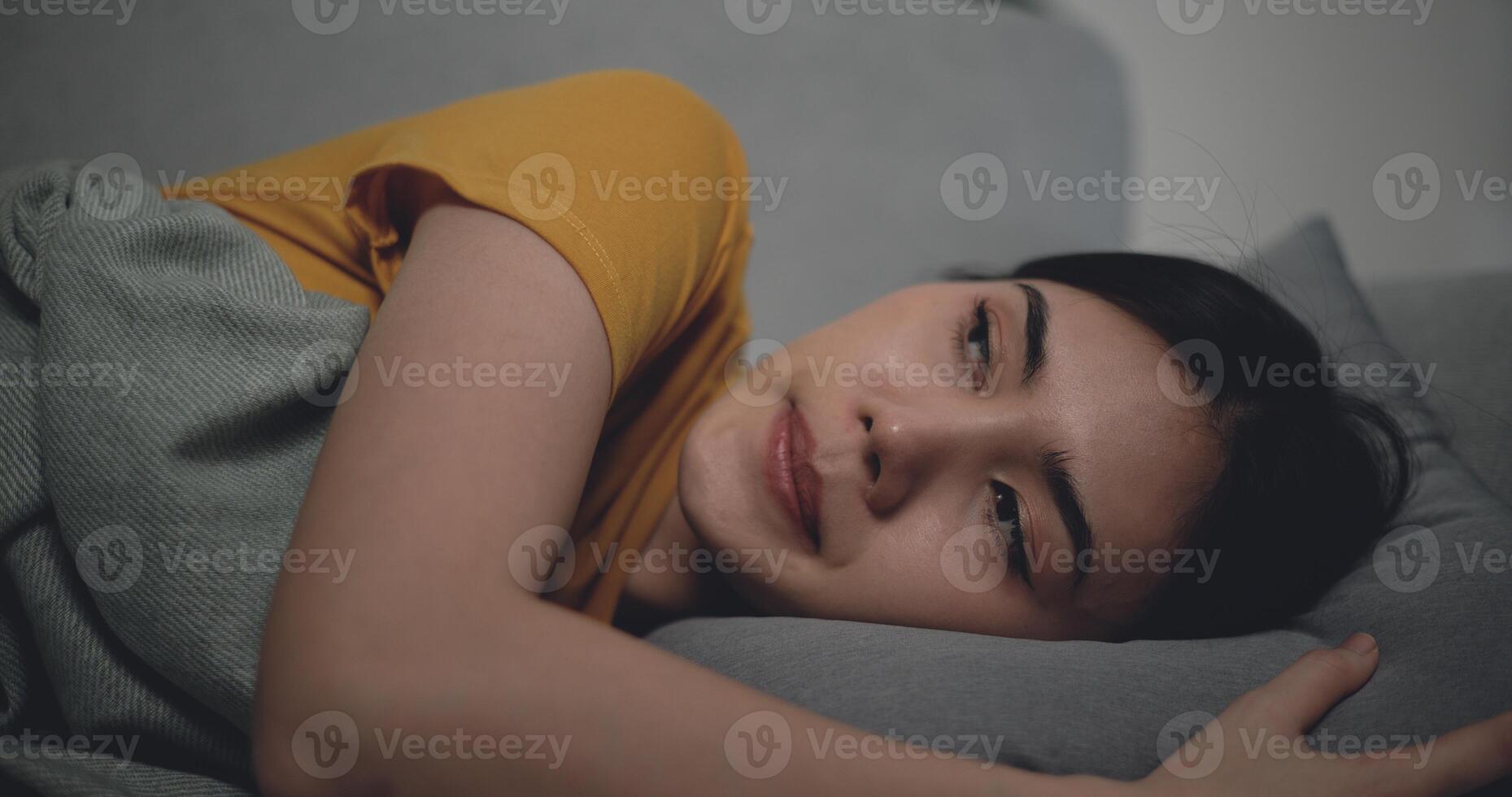 Sick woman covered with a blanket lying in bed with high fever photo