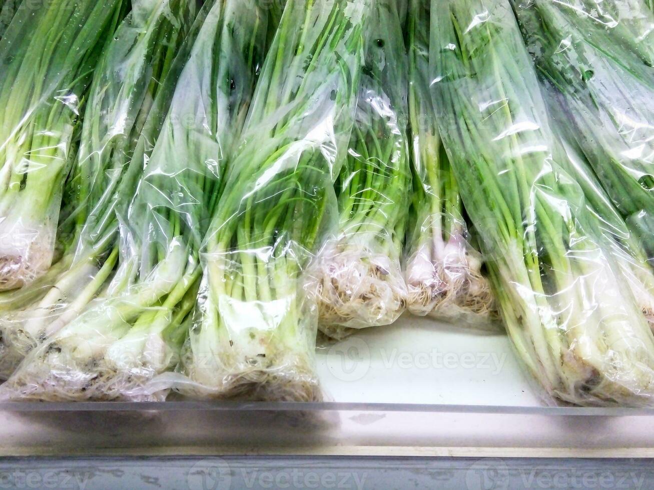 green onion with  plastic bag on display In the mall , fresh Onion photo