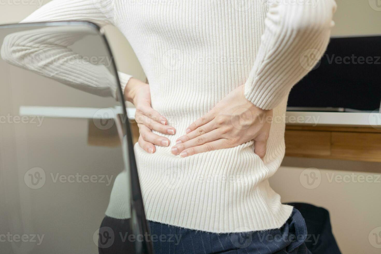 cuerpo músculos rígido problema, dolor asiático joven mujer, niña dolor atrás, tramo mientras sentado trabajo en silla a hogar, participación masajear frotamiento, herir o doloroso, cuidado de la salud gente, oficina síndrome . foto