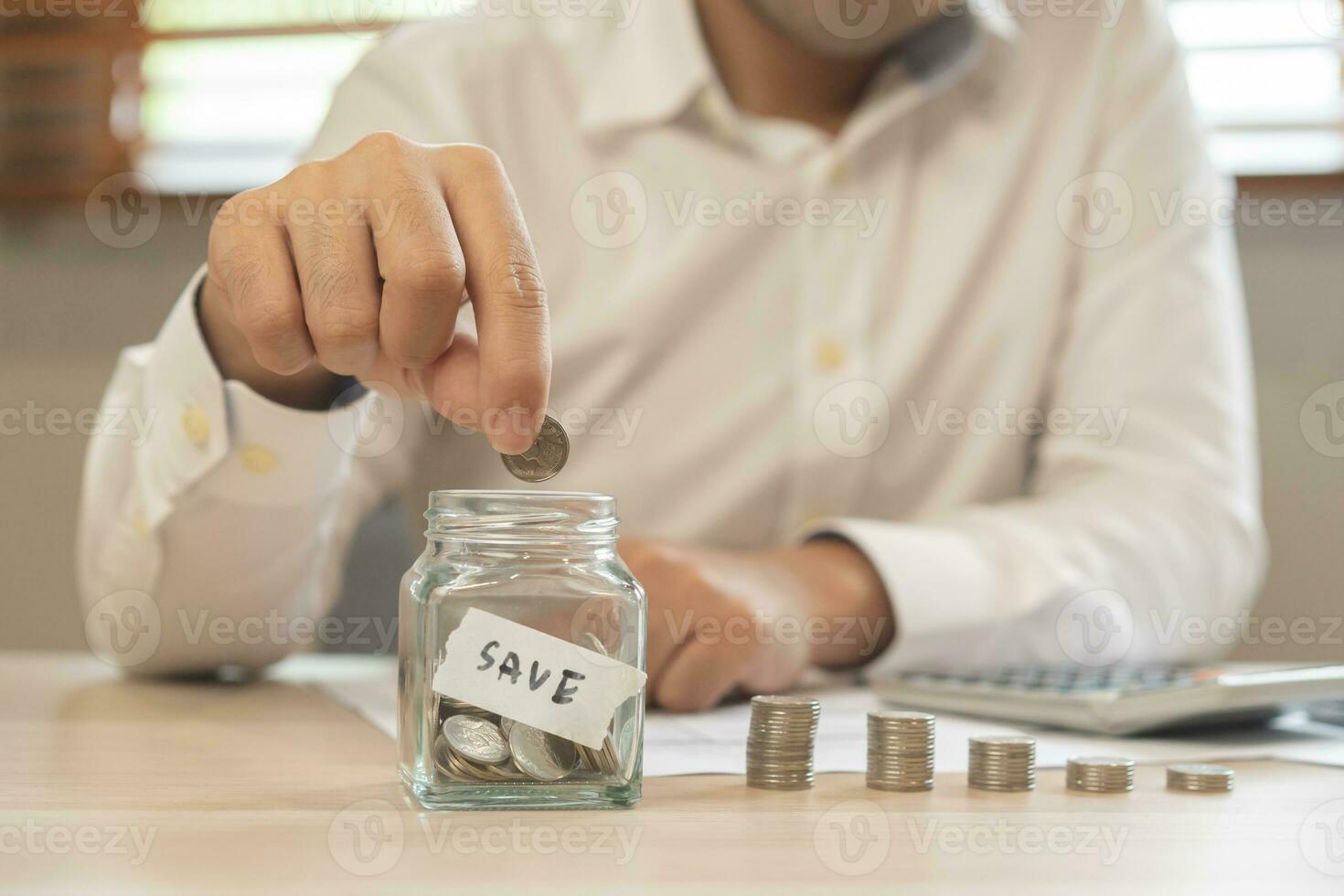 Close up hand of asian young businessman, male is press calculator to calculate cost, financial plans to spend enough money on his income for saving money and payment, payday. Finance people concept. photo