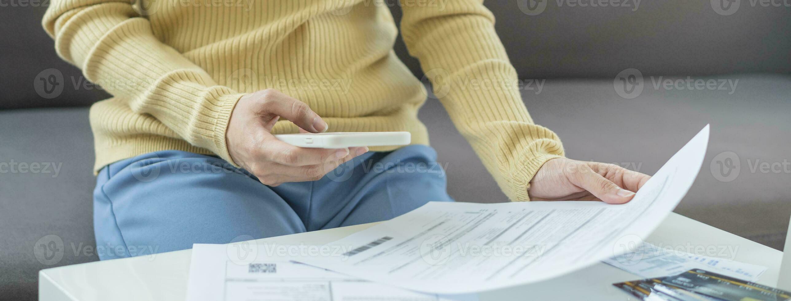 Cost, budget asian young woman calculate expense, spending and check from invoice, use smartphone, mobile phone pay payment internet online of credit card at home. Technology of finance, financial. photo