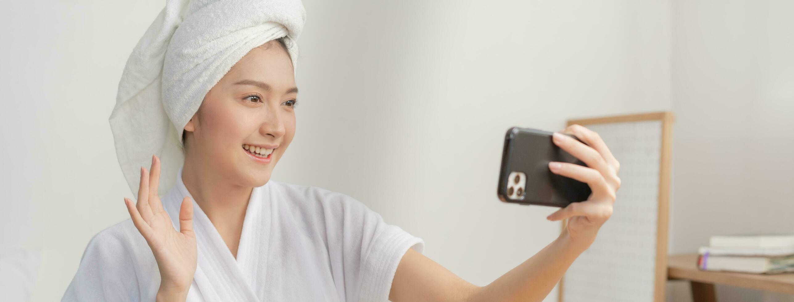 Beauty blogger, asian young woman hand in using mobile phone selfie her photo, makeup face by cosmetic while recording tutorial video to share on social media. Business online influencer on smartphone photo