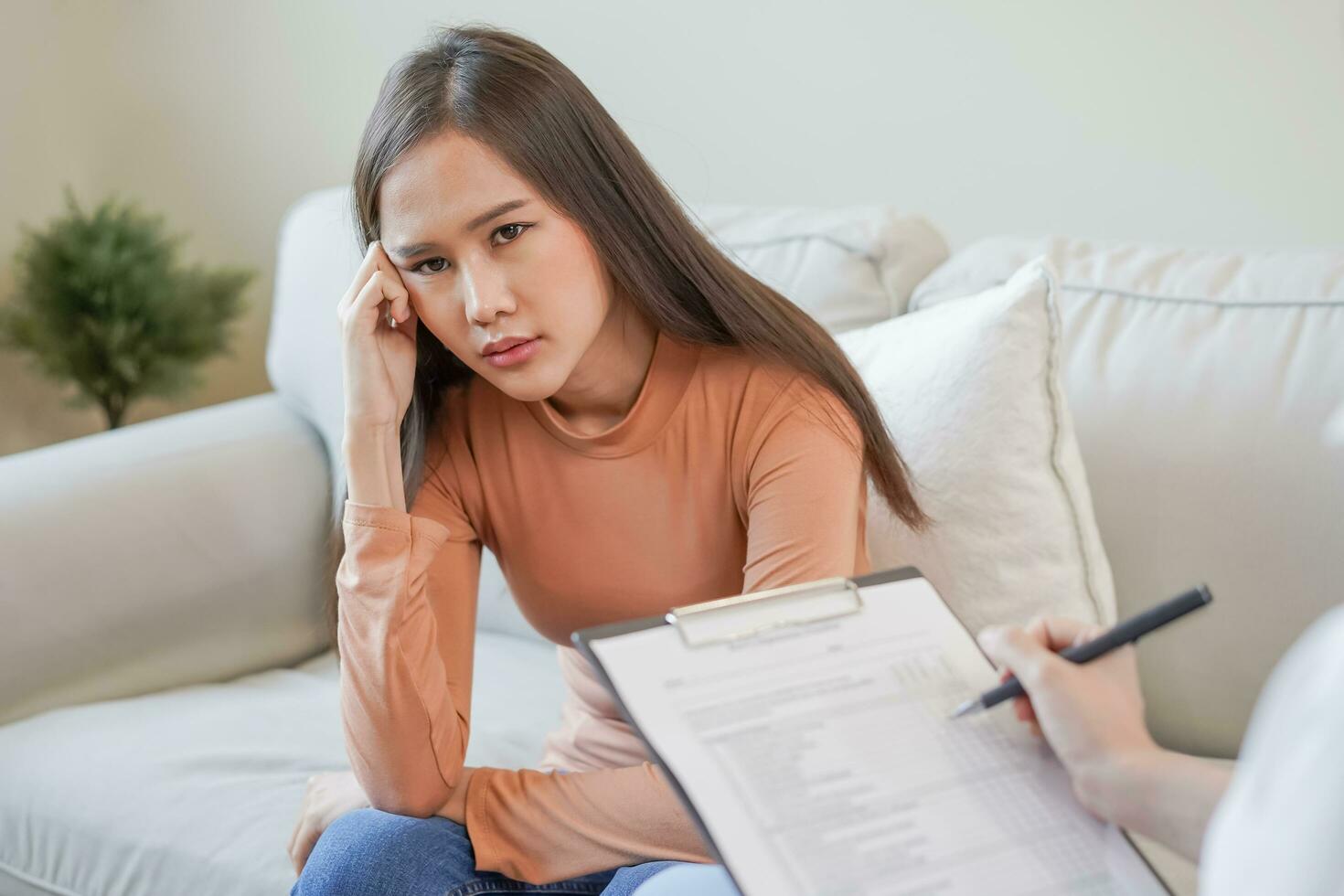 psicología, depresión. triste, sufrimiento asiático joven mujer consultante con psicólogo, psiquiatra mientras paciente asesoramiento mental con médico mujer tomando notas a clínica. alentador, terapia. foto