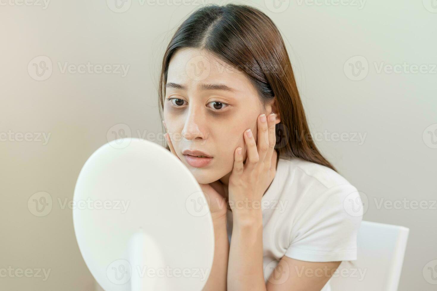 Bored, insomnia asian young woman, girl looking at mirror, without makeup, touch under eyes with problem of dark circles, puffiness, swollen or wrinkles on face. Sleepless, sleepy people, copy space photo