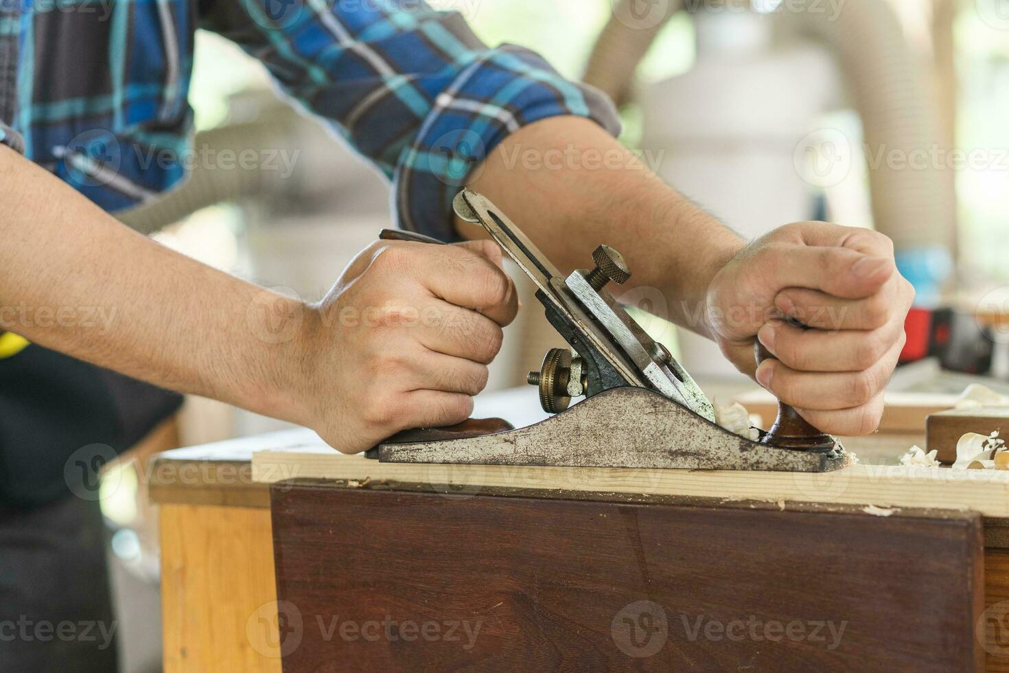 Carpentry professional, asian young man, male carpenter use machines or tool, shavings rugged on wood, timber at industrial. Woodwork, furniture making, construction industry. Owner small business. photo