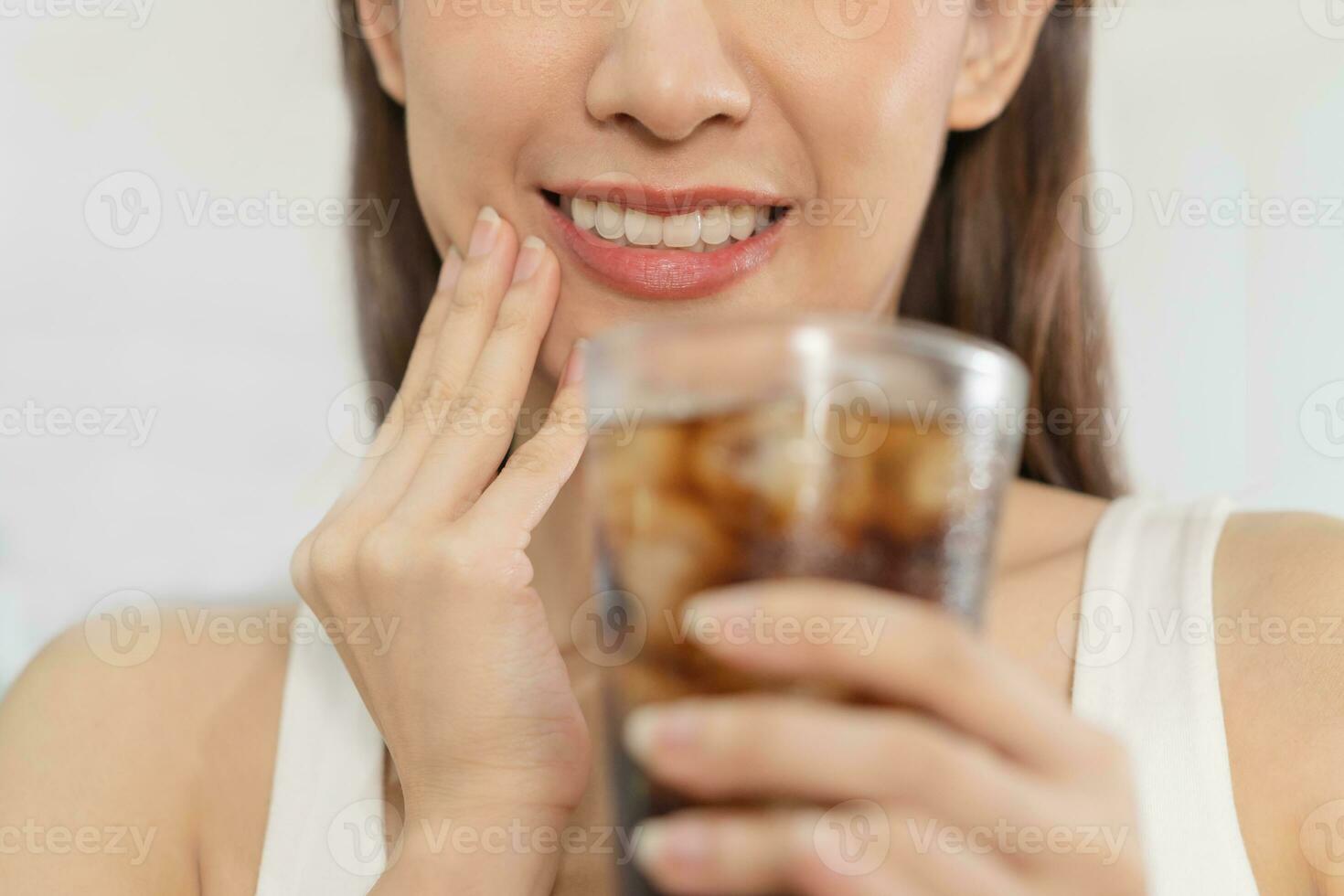 Health asian young woman touching her mouth, expression, suffering from toothache, decay or sensitivity cavity molar tooth or inflammation drink cold, sparkling water at home.Sensitive teeth people. photo
