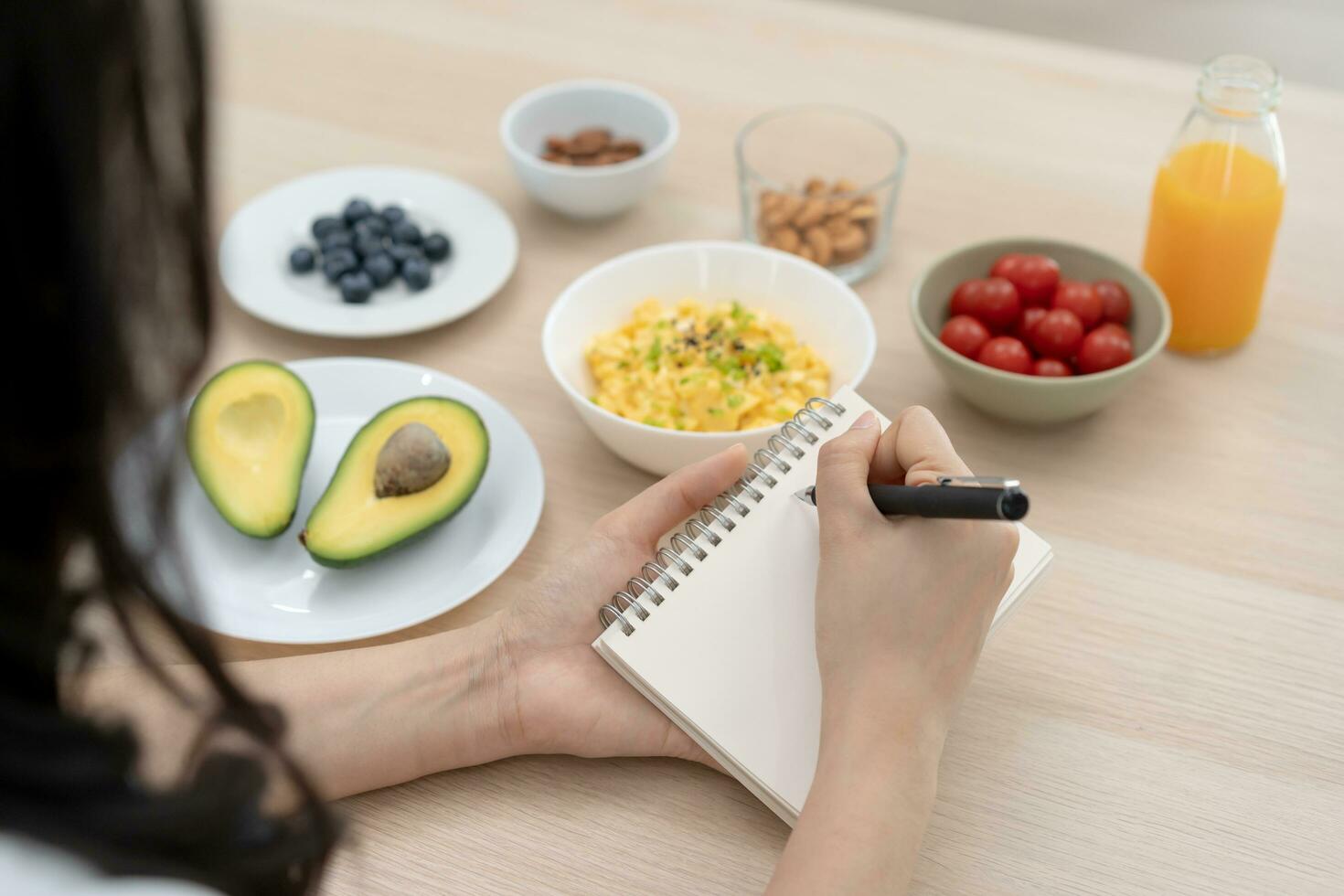 Diet, Dieting hand of asian young woman, girl write diet plan nutrition on table is different food ingredients in the green. Nutritionist of healthy, nutrition of weight loss, health care people. photo