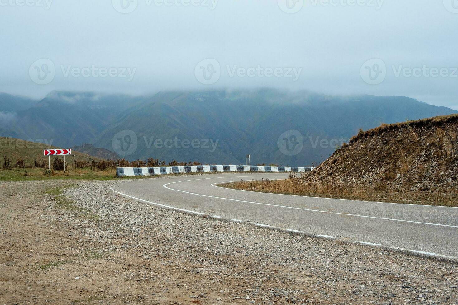 vacío Mañana autopista mediante el aprobar, Derecha giro . hermosa asfalto autopista, autopista, autopista mediante de caucásico paisaje montañas colinas a frío brumoso clima en medio octubre. foto