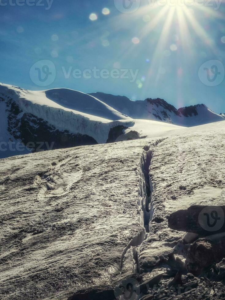 A fault in a glacier, a dangerous crack in the ice on the snowy slope of a glacier. photo