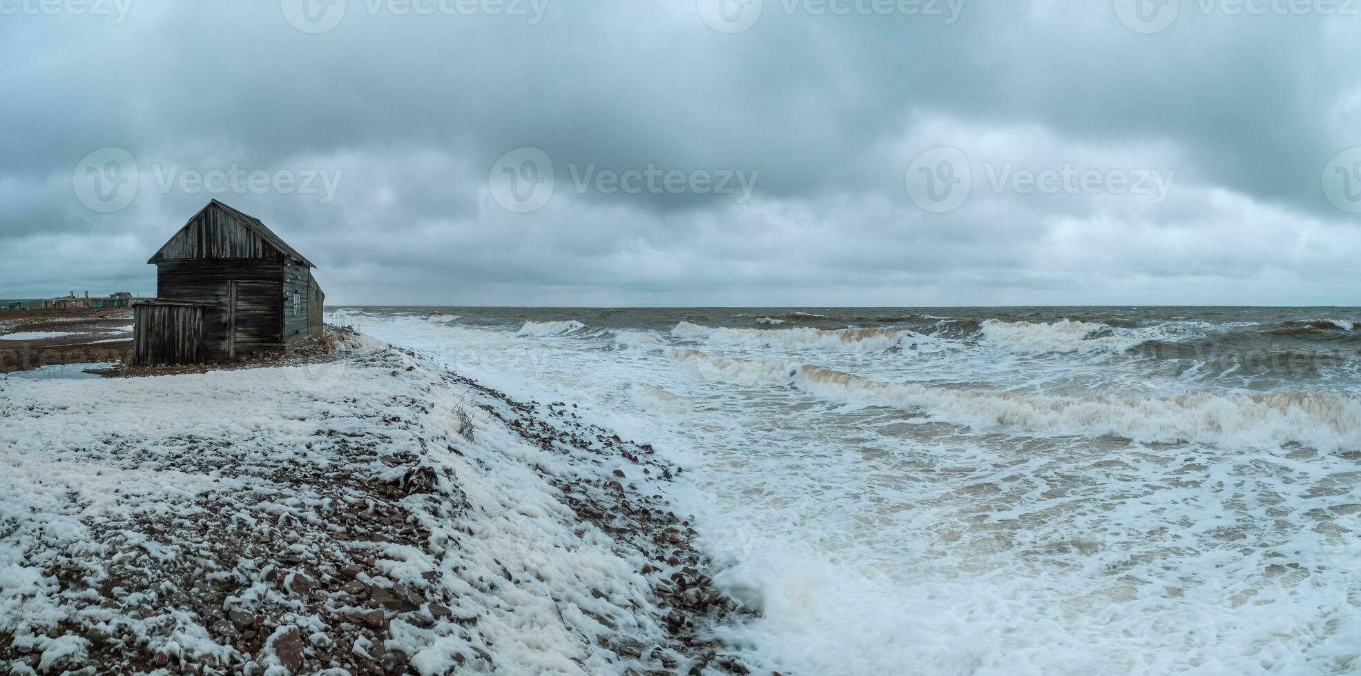 Wide panoramic view of dramatic seascape with a raging White sea and a fishing hut on the shore. Kandalaksha bay. Umba. Russia photo