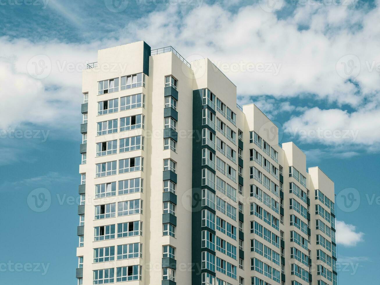 Modern beautiful new high-rise residential building. Colored wall on the background of blue sky. Copy space. photo