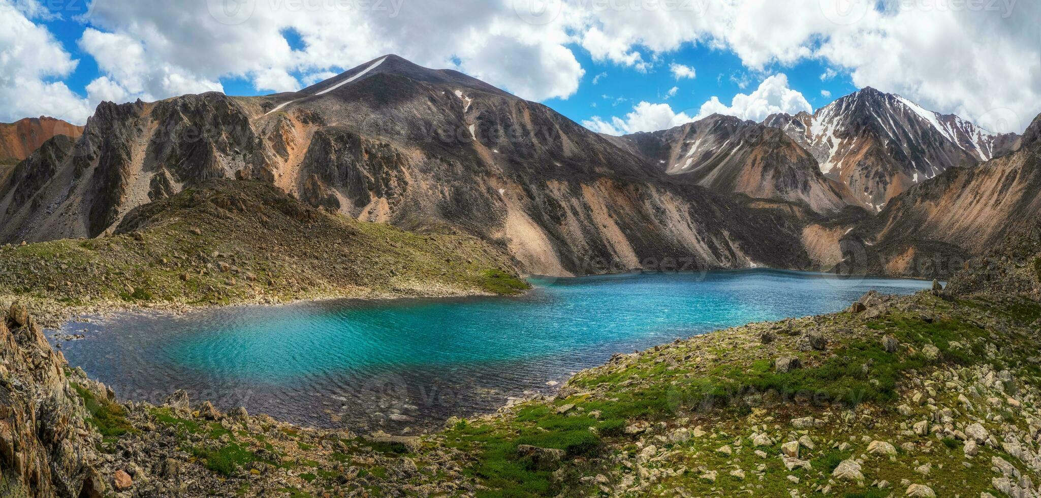 Panoramic spring view to mountain lake on background of mountains. Atmospheric green landscape with lake in high mountain valley. Altai Mountains. photo