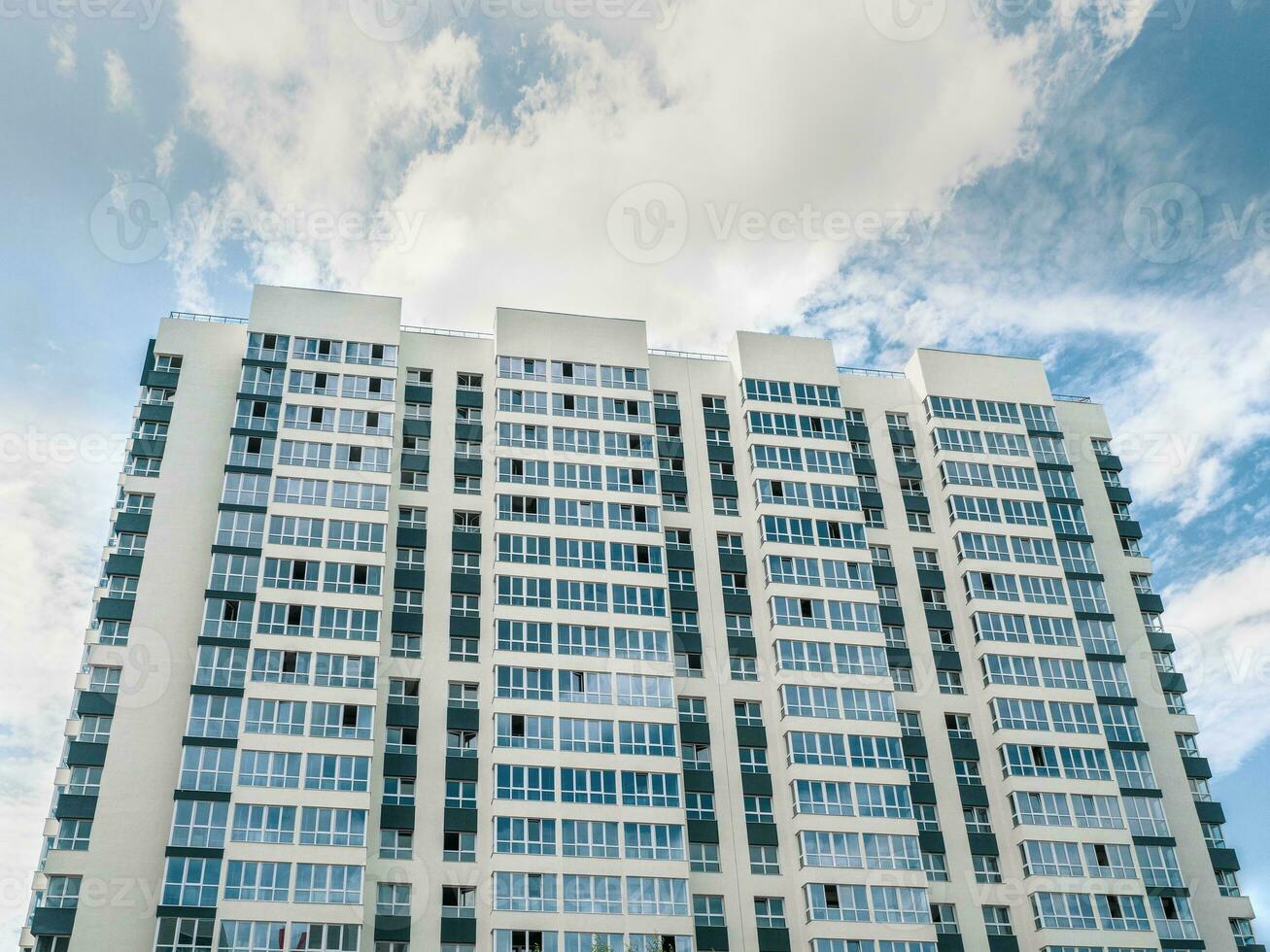 Modern beautiful new high-rise residential building. Colored wall on the background of blue sky. Copy space. photo