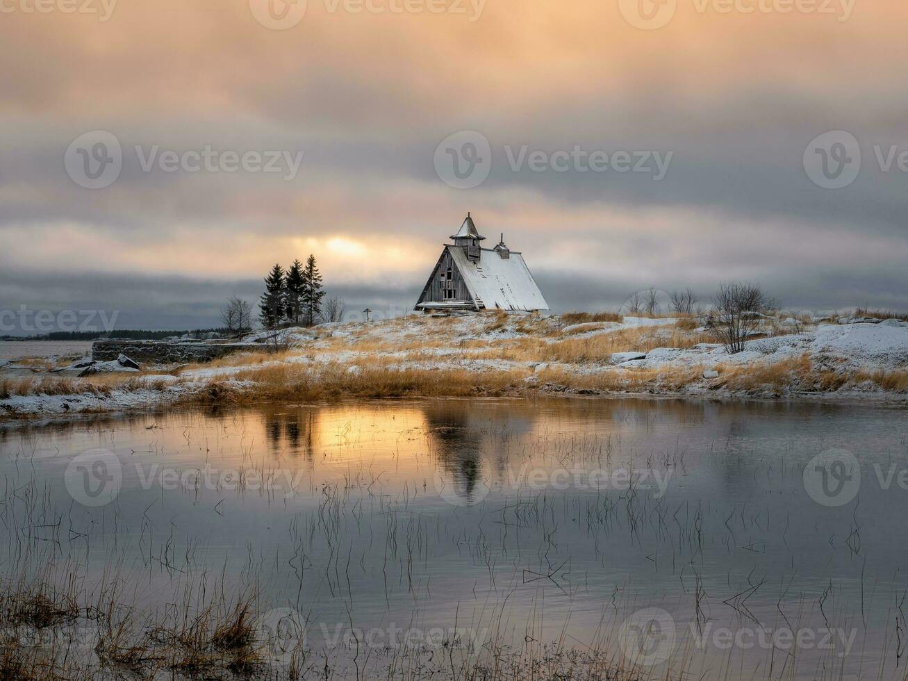 Beautiful evening winter landscape with a small authentic wooden house at dusk on a cliff. photo