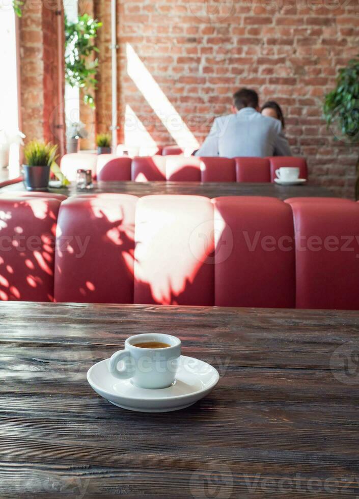 Espresso cup on a wooden table in the interior of the cafe photo