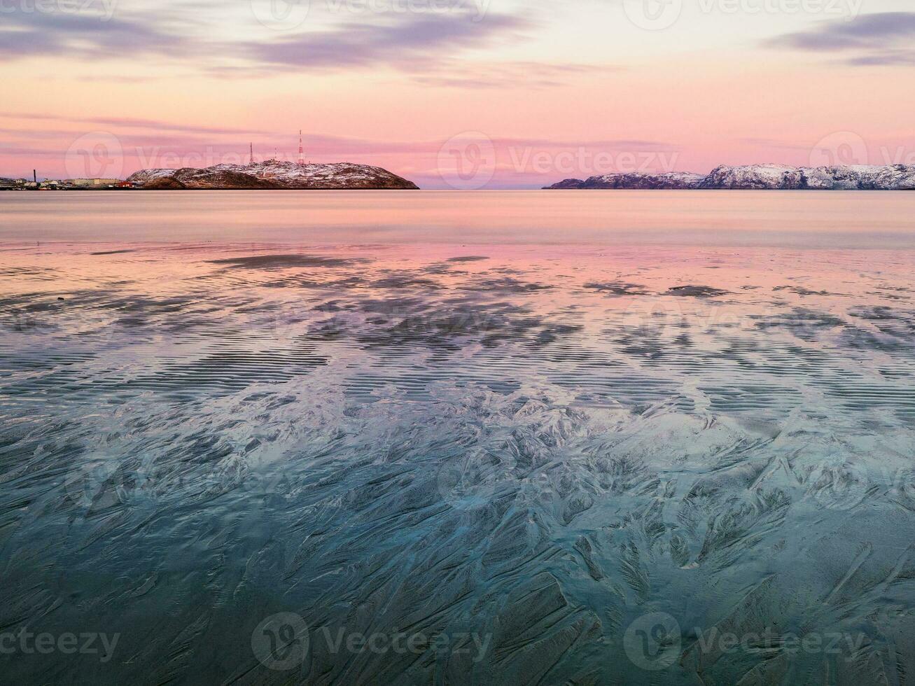 Fancy patterns of water on the Arctic seashore of the Barents sea. Amazing sunset in the North of the Kola Peninsula photo