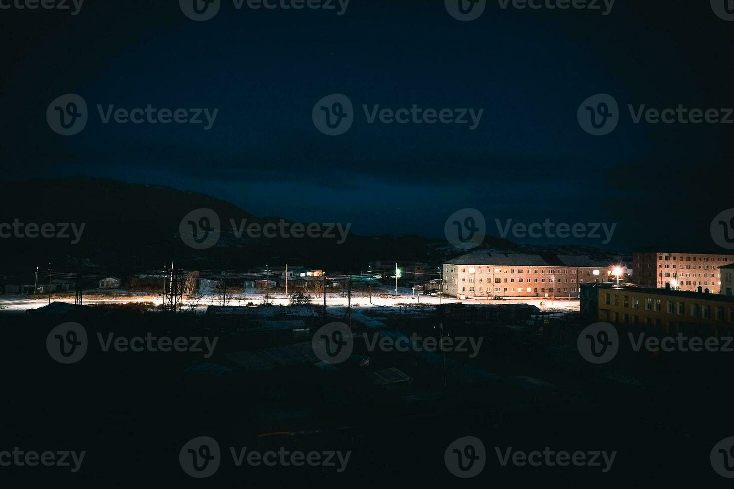 Night view of Arctic village Lodeynoye on the shore of the Barents sea. Empty winter evening  road between. photo