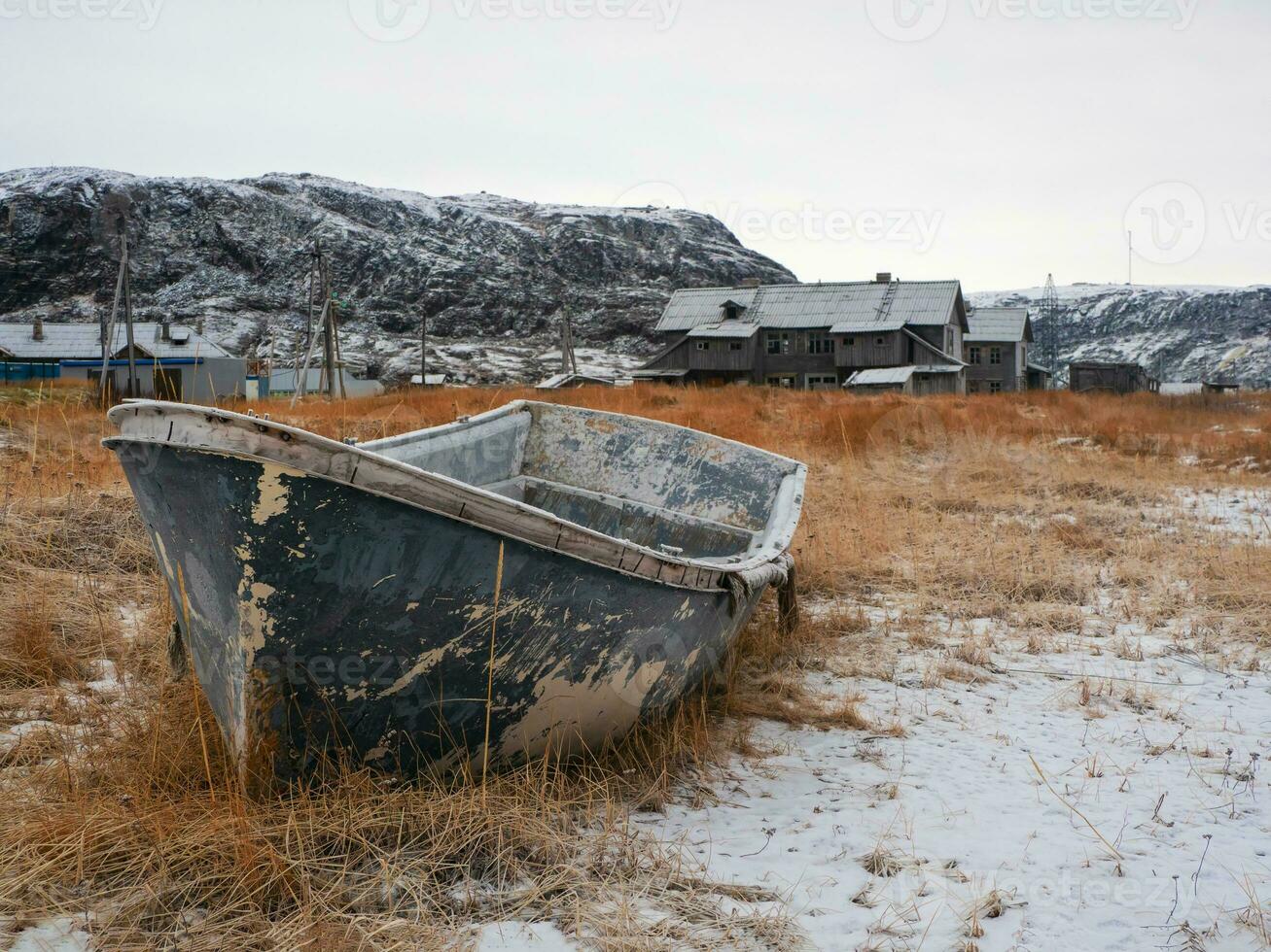 un oxidado congelado pescar bote. antiguo pescar pueblo en el apuntalar de el Barents mar foto