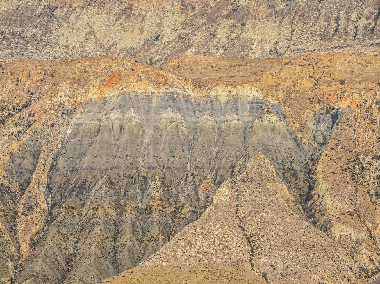 Cross section of rocks. Geological layers. Colored layers of stones in section of the mount, different rock formations and soil layers. photo