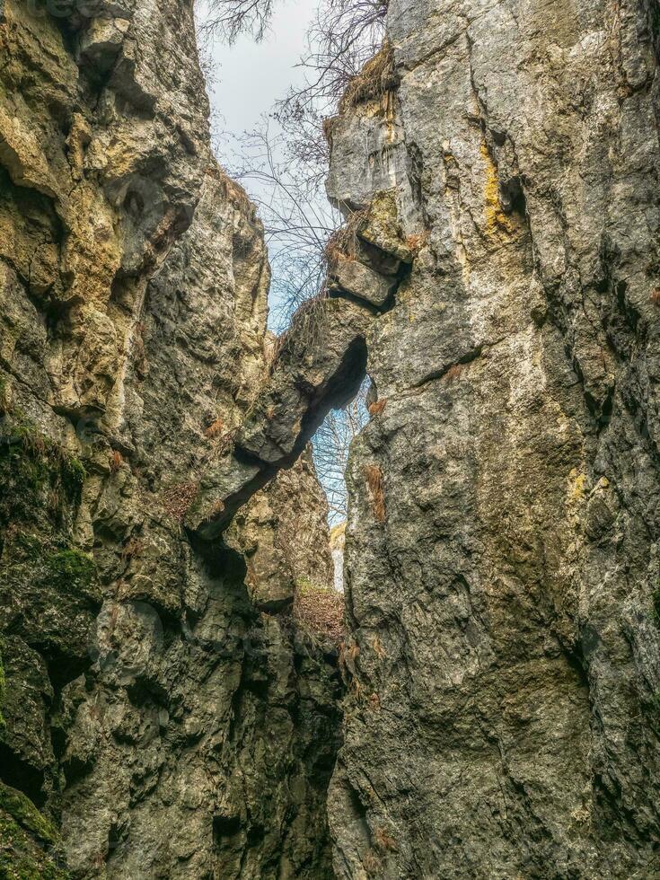 A dangerously overhanging rock in a crevice between the rocks. photo