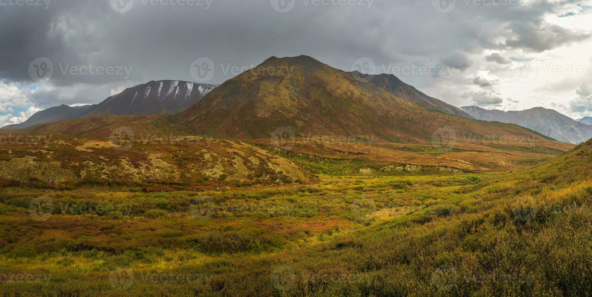 Dramatic rainy alpine landscape with autumn golden valley and da photo