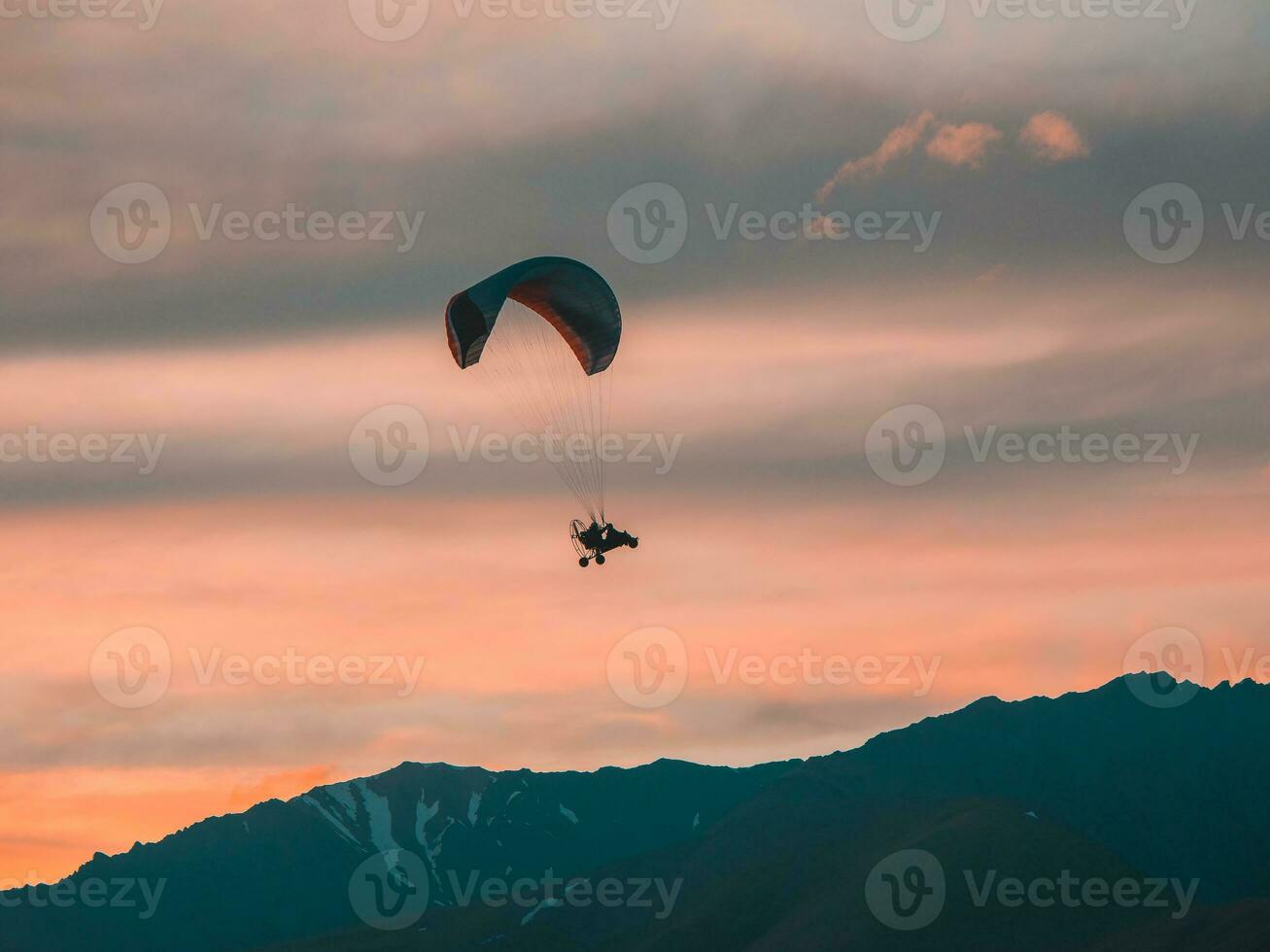 Extreme sports. Powered parachute over the mountains at sunset. photo