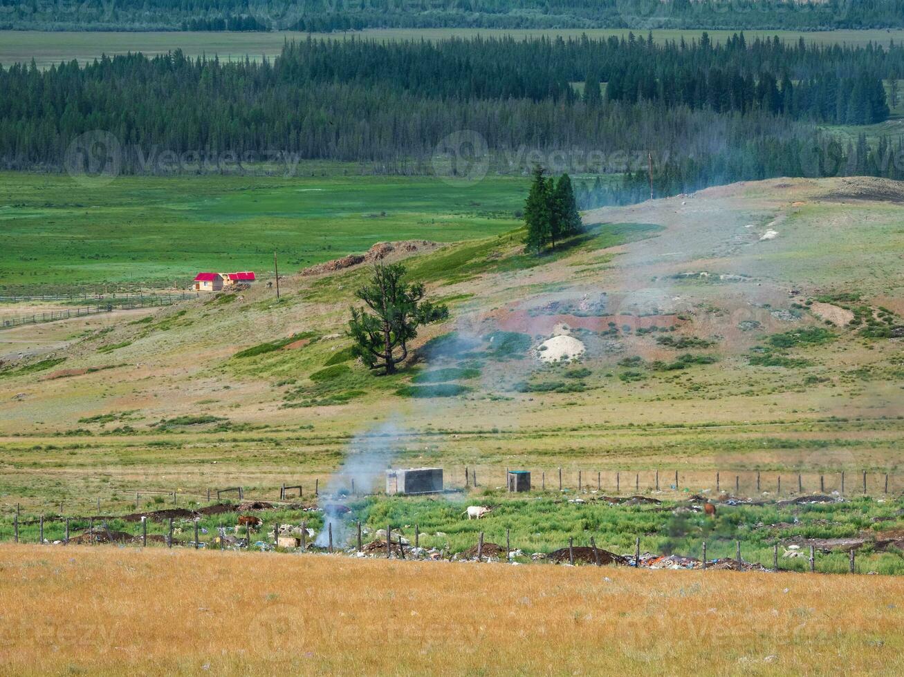 Landfill garbage fire inferno in mountain steppe with heavy smoke. photo