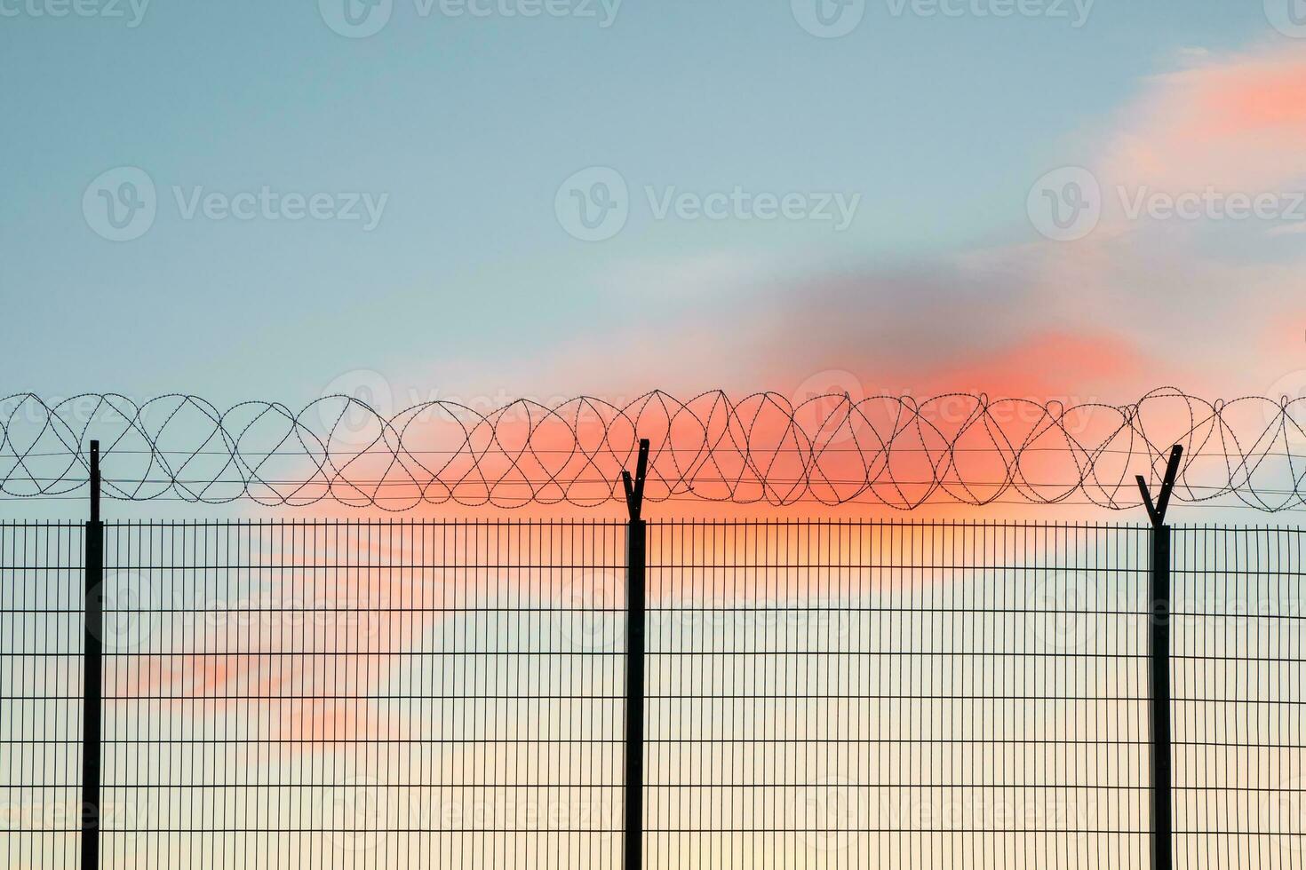 Wire mesh fence with colorful sky background. photo