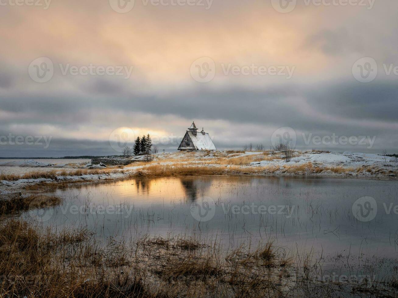 Beautiful evening winter landscape with a small authentic wooden house at dusk on a cliff. photo