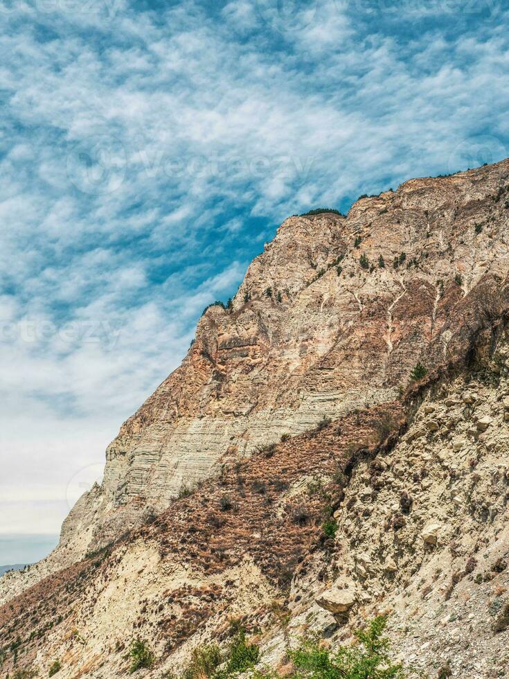 Beautiful mountain landscape with red rounded rocks. Big rock formation, different rock formations and soil layers. Distant mountain plateau. photo