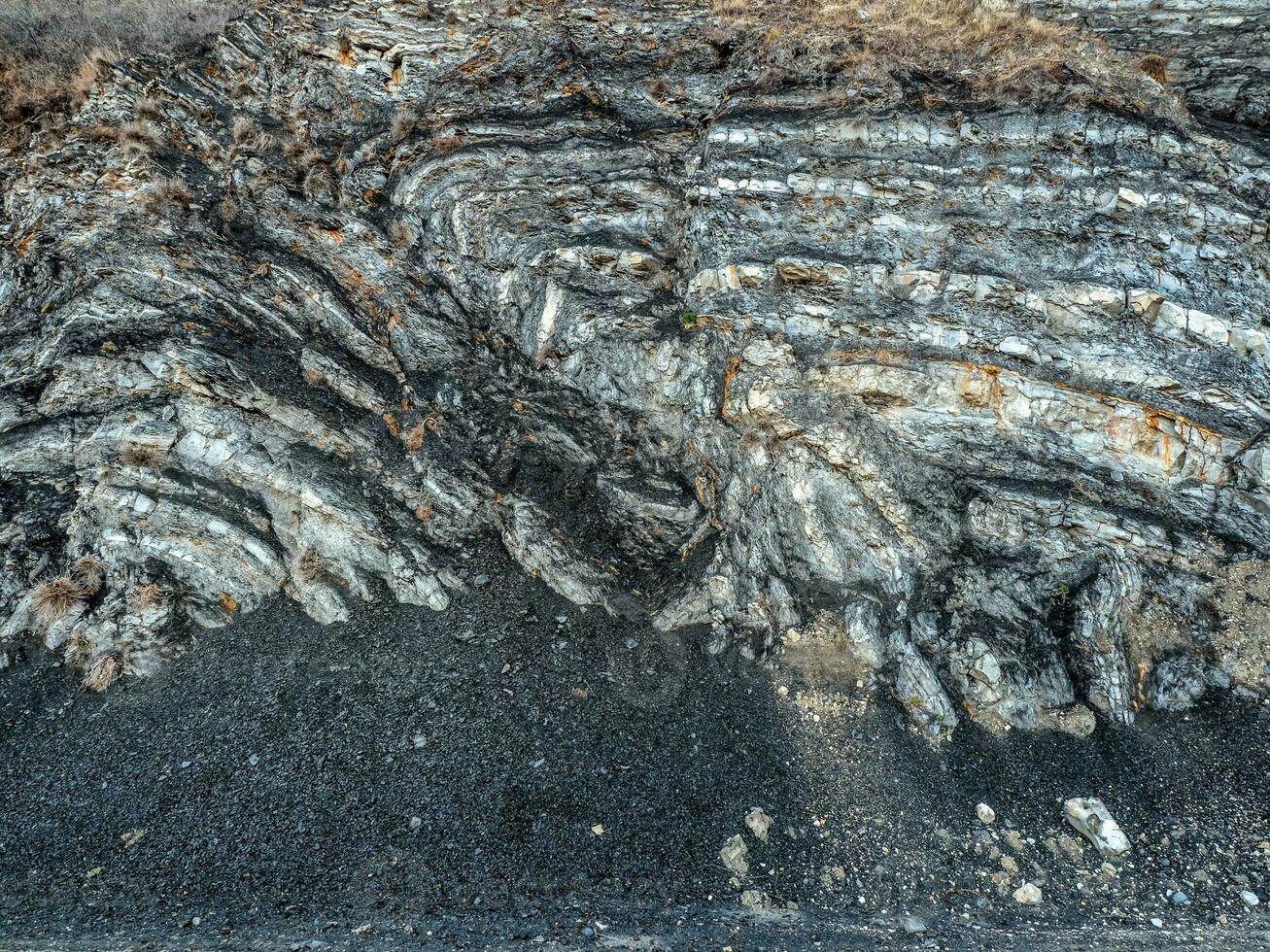 Stone texture. Colored layers of stones in section of the mount, different rock formations and soil layers. photo