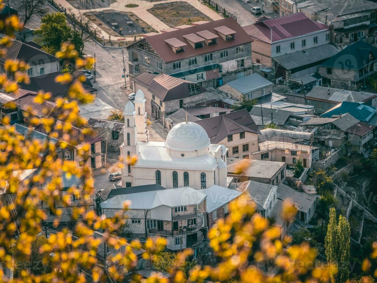 White mosque in the center of a mountain village. Aerial landscape and countryside of cityscape in Gunib. Dagestan. photo