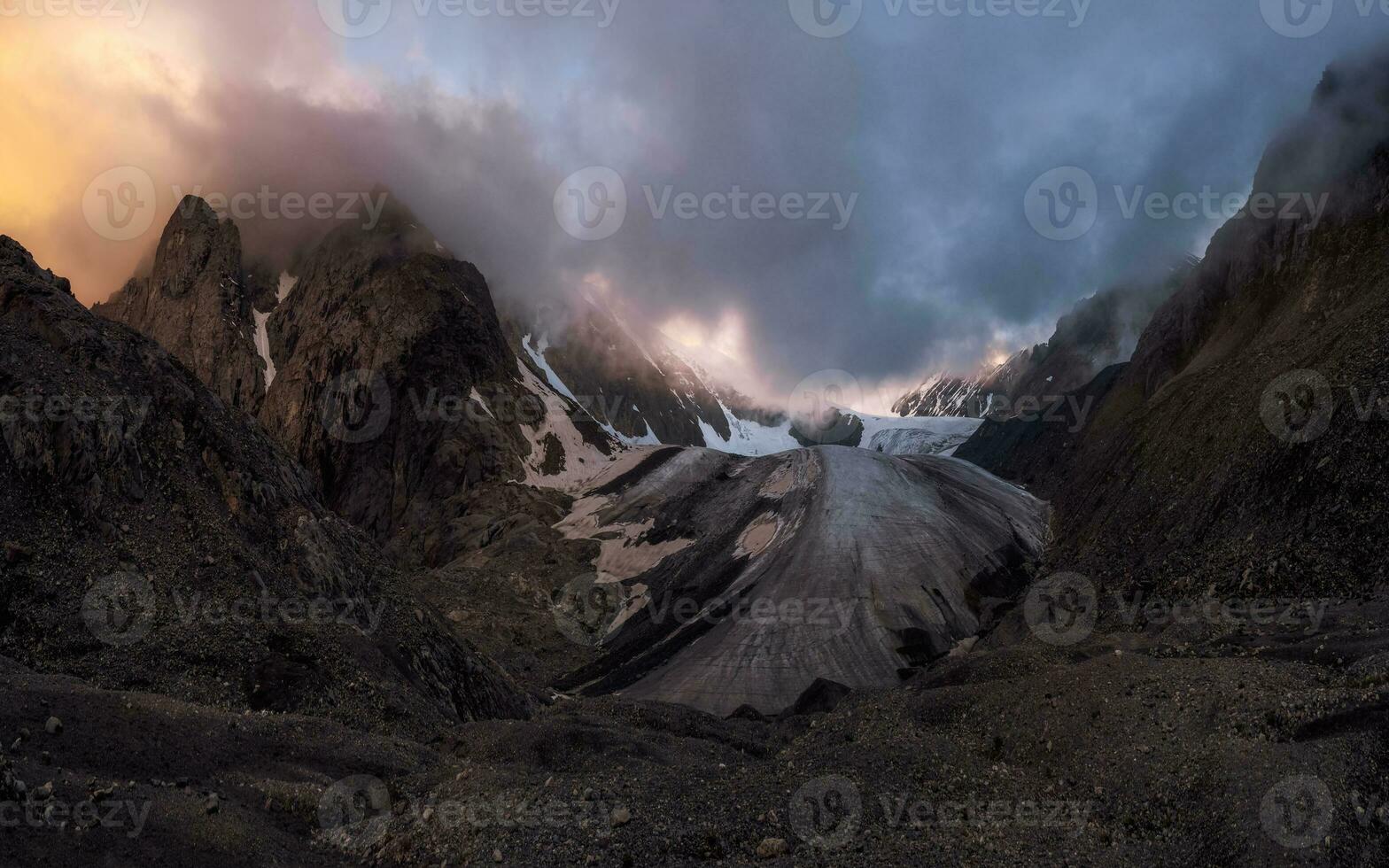 Majestic glacier is illuminated by the bright golden evening sun. Panoramic view. Altai Mountains. photo