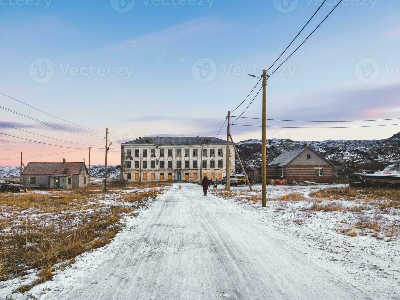 Authentic Russian northern village, old dilapidated wooden houses, harsh Arctic nature. photo