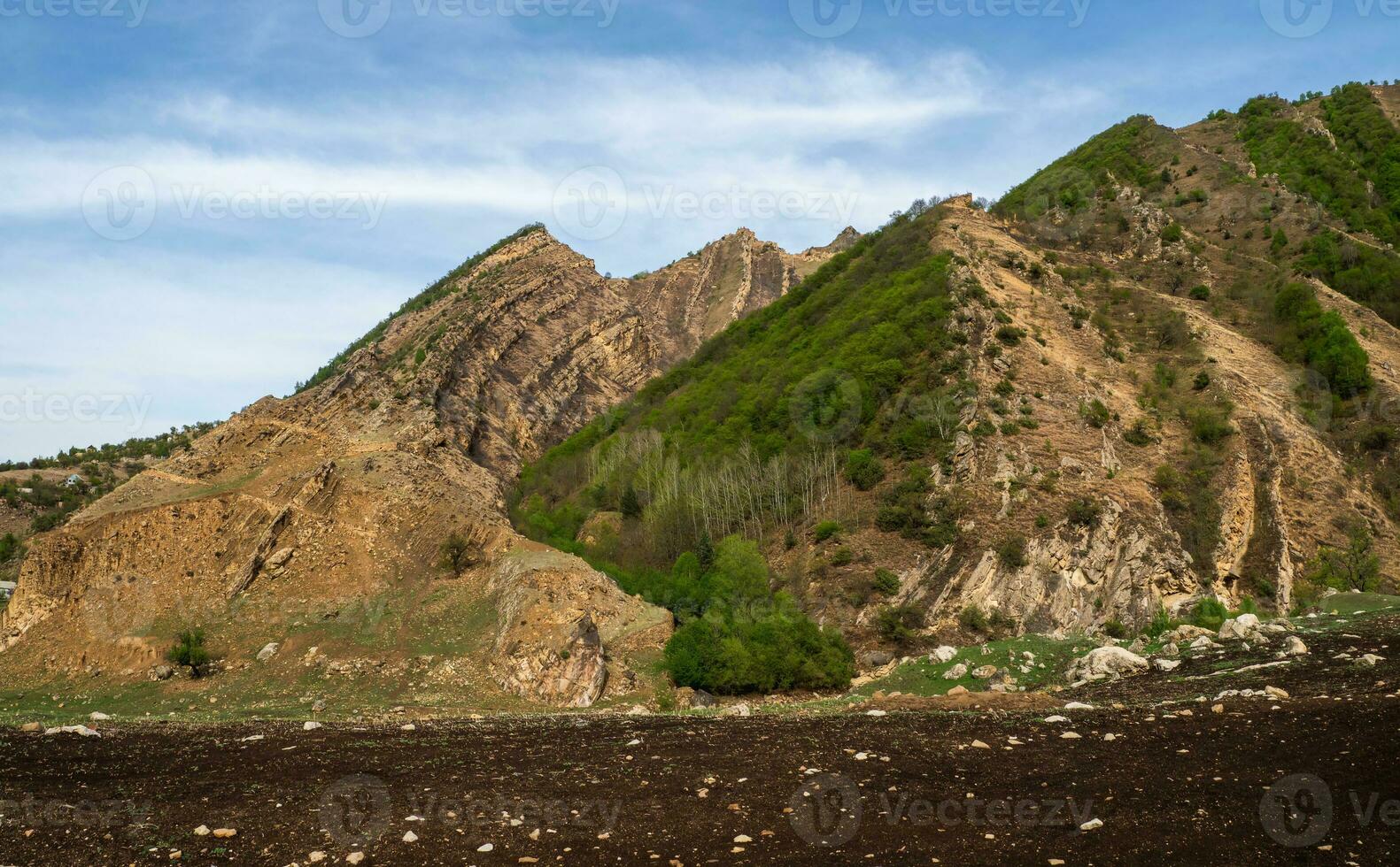 High-altitude plateau with a small field, complex agriculture, natural attractions, sharp mountains photo