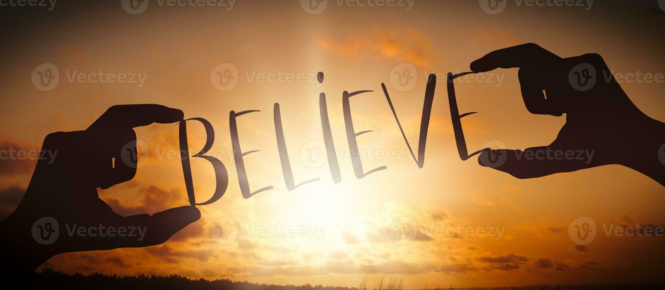 Believe - Human Hands Holding Black Silhouette Word photo