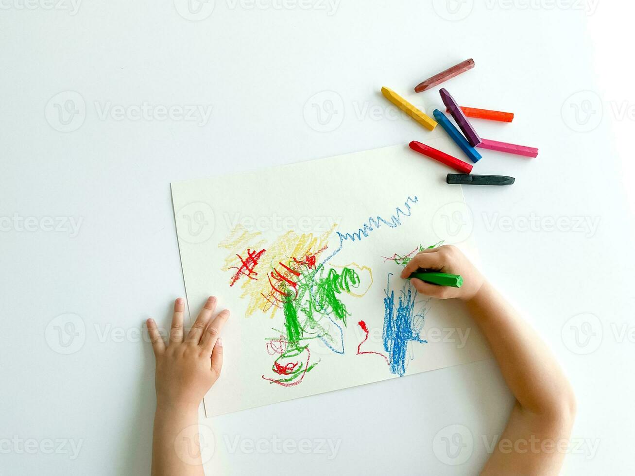 small child draws with pastel crayons on white table. fathers day photo