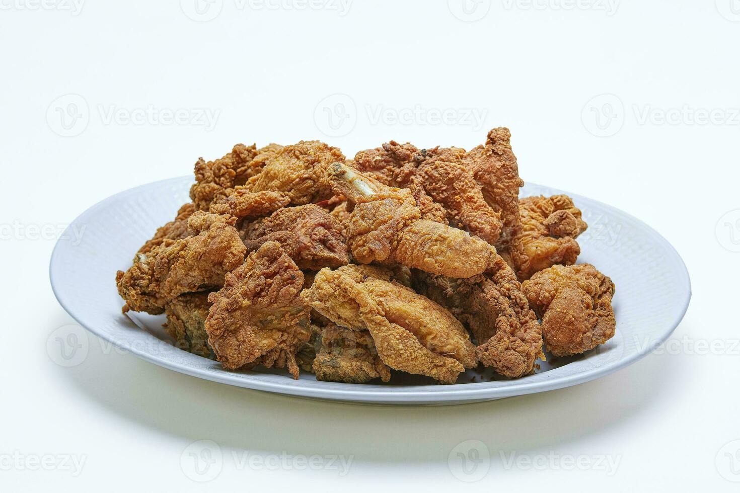 Pile of Crispy Fried Chicken with flour coating on a plate, isolated white background photo