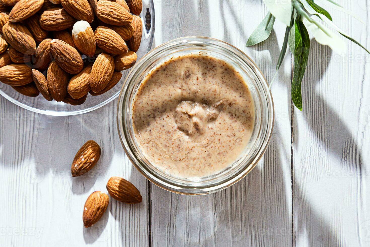 Jar of almond butter with almonds heap. Homemade almond butter, natural, healthy food. photo