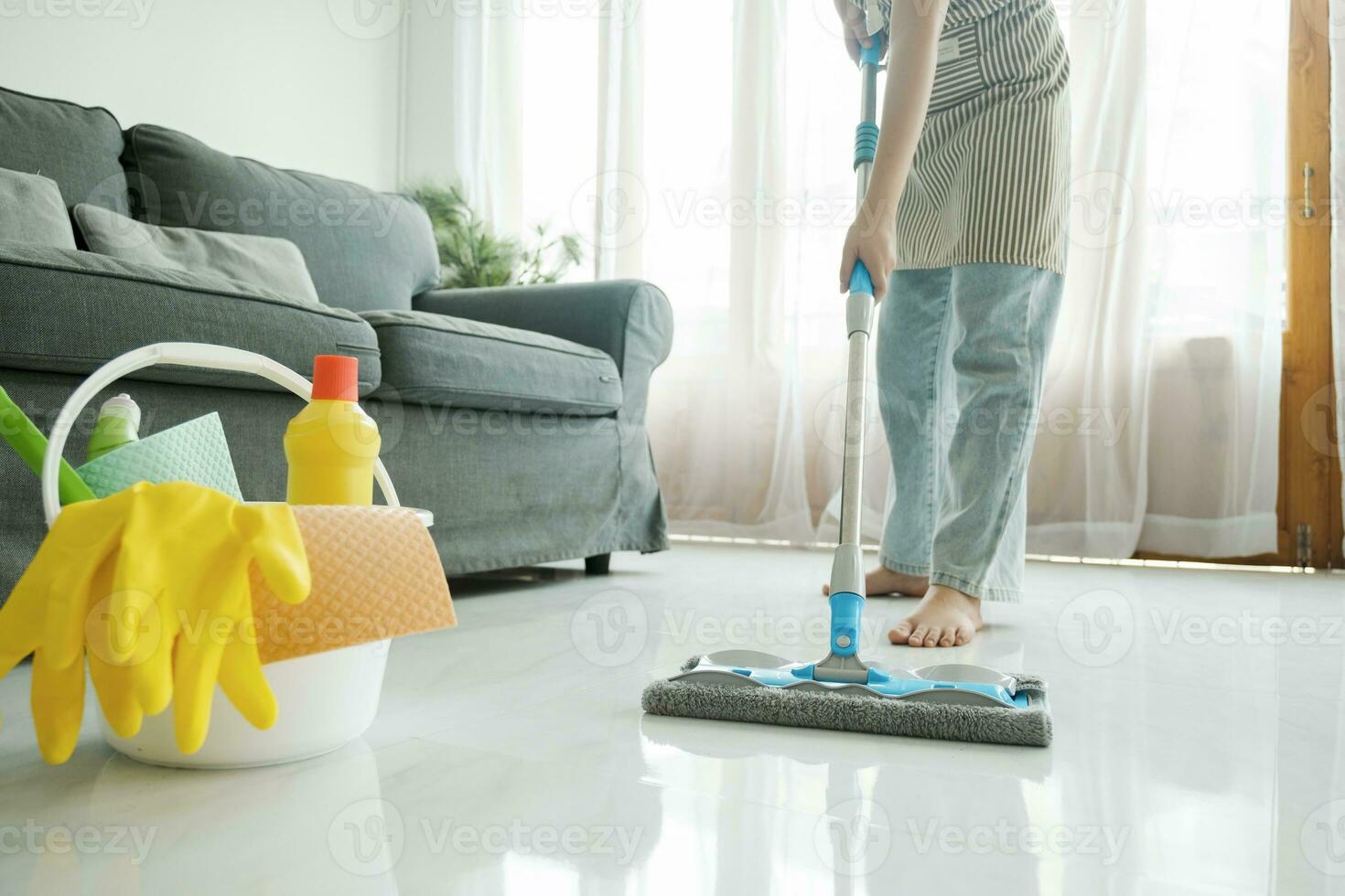 joven mujer limpieza piso utilizando fregona a hogar. foto