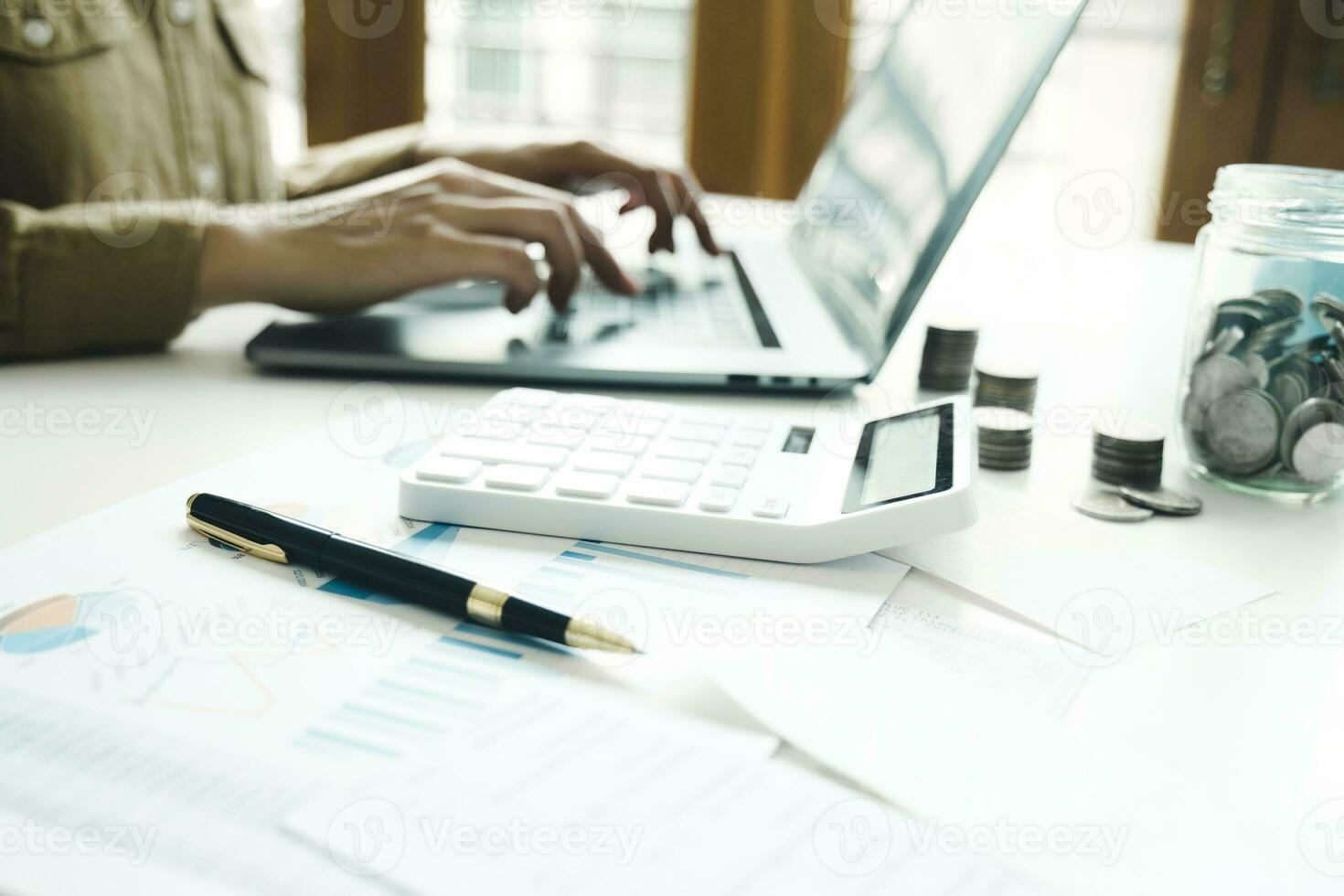 Woman accountant working on laptop computer while counting taxes online. photo